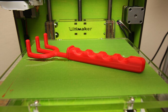 One of my first 3D prints ever, a red garden rake, made on my green Ultimaker named Kermit.